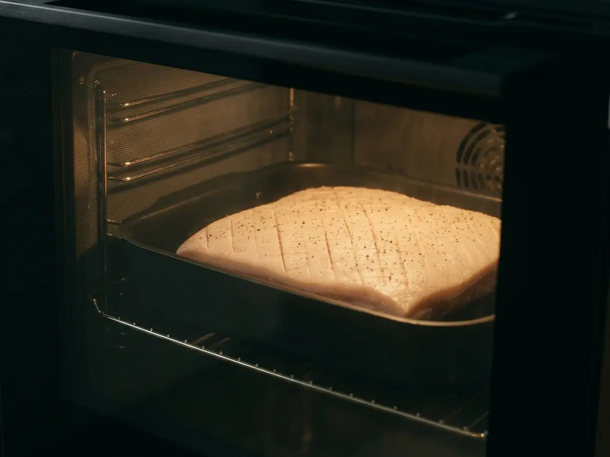 Ribbe under langtidssteking på 90 grader sett gjennom ovnens glassdør